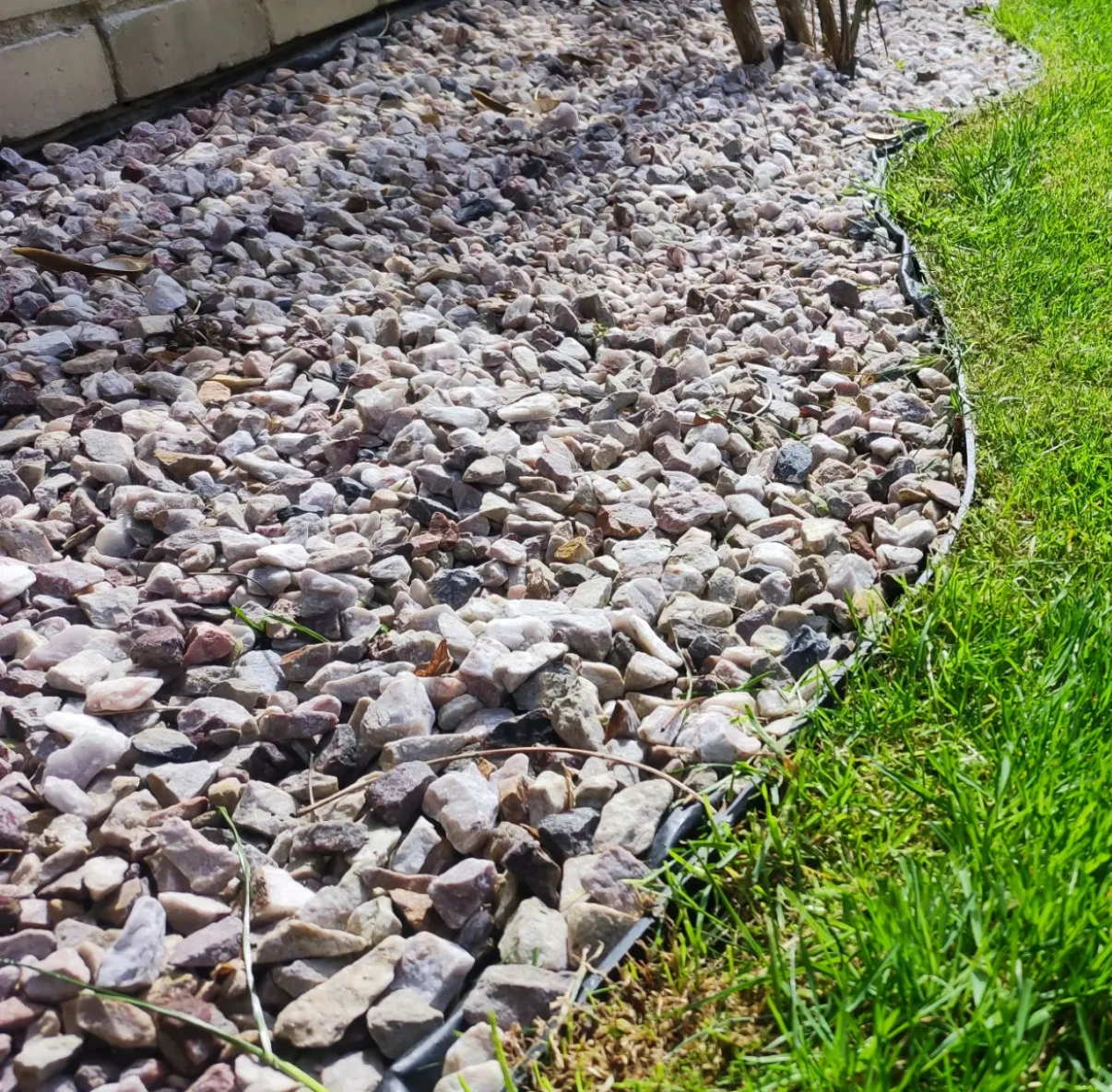 Garden bed with pebbles and grass border